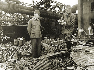 Риозо Асано (слева) осматривает развалины своего сталелитейного завода в Токио